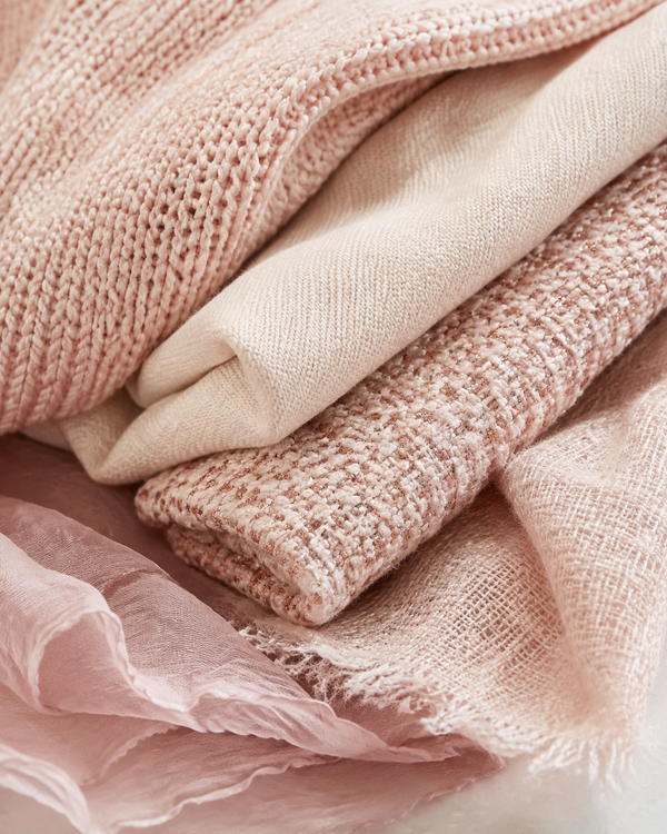 Close-up of recycled knit and woven fabric swatches in blush, cream and rose-gold tones